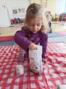 Dziewczynka wsypuje mąkę do szklanki.